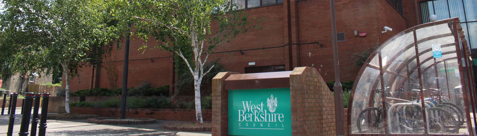 Exterior view of a council building with a bike stands and a "West Berkshire Council" sign